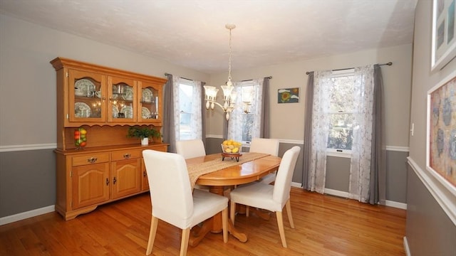 dining area featuring an inviting chandelier and light hardwood / wood-style floors