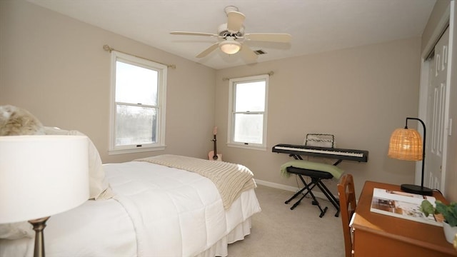 bedroom with light carpet, ceiling fan, and a closet