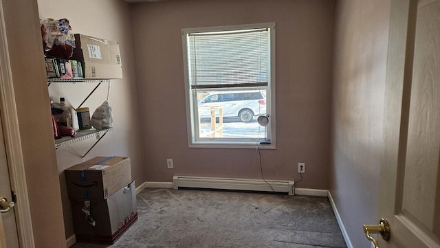 carpeted empty room featuring plenty of natural light and a baseboard heating unit