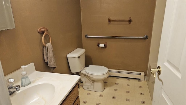 bathroom featuring toilet, vanity, and baseboard heating