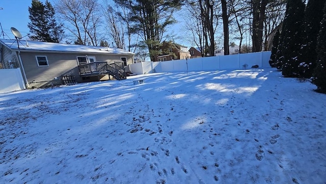 yard layered in snow featuring a wooden deck