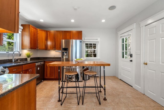 91 Freeman St, Newton, MA 02466 - kitchen featuring stainless steel appliances, recessed lighting, brown cabinetry, dark stone countertops, and light tile patterned flooring