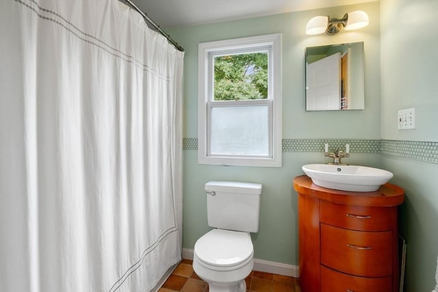 bathroom featuring curtained shower, vanity, toilet, and baseboards