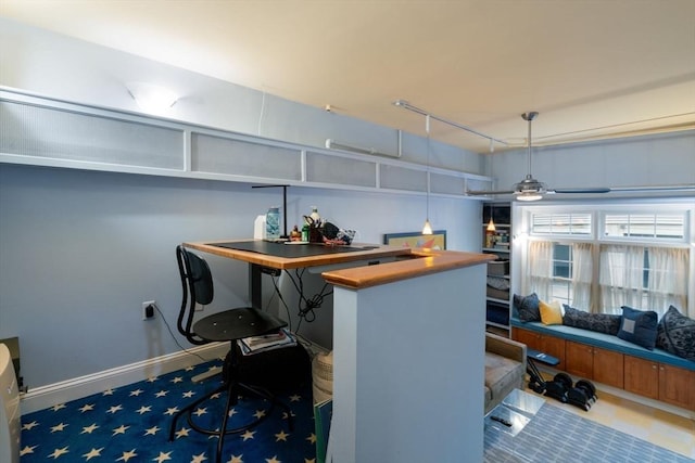 bar with track lighting, baseboards, a ceiling fan, and decorative light fixtures