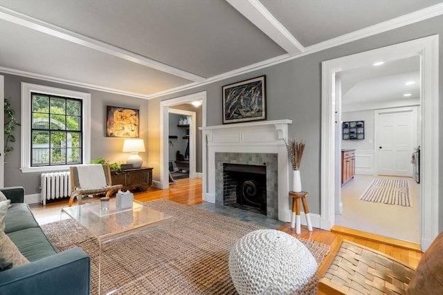 living room featuring ornamental molding, radiator, and light wood-style flooring