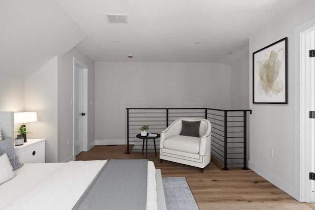 bedroom featuring hardwood / wood-style flooring and vaulted ceiling