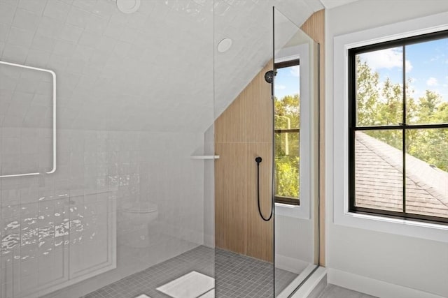 bathroom featuring tile patterned flooring, vaulted ceiling, and walk in shower