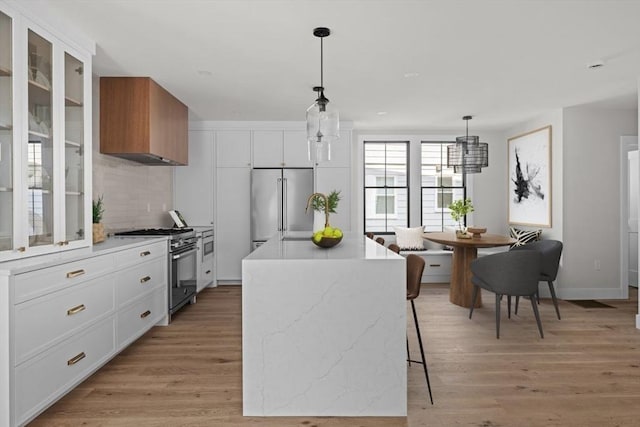 kitchen featuring a center island, white cabinets, hanging light fixtures, and premium appliances