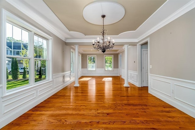 84 Bruce Rd, Concord, MA 01742 - unfurnished dining area with decorative columns, a chandelier, a decorative wall, plenty of natural light, and ornamental molding