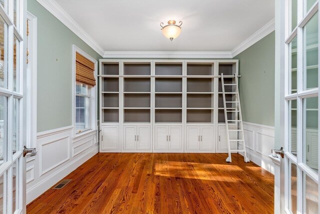 84 Bruce Rd, Concord, MA 01742 - unfurnished room featuring crown molding, wood finished floors, a wainscoted wall, french doors, and a decorative wall