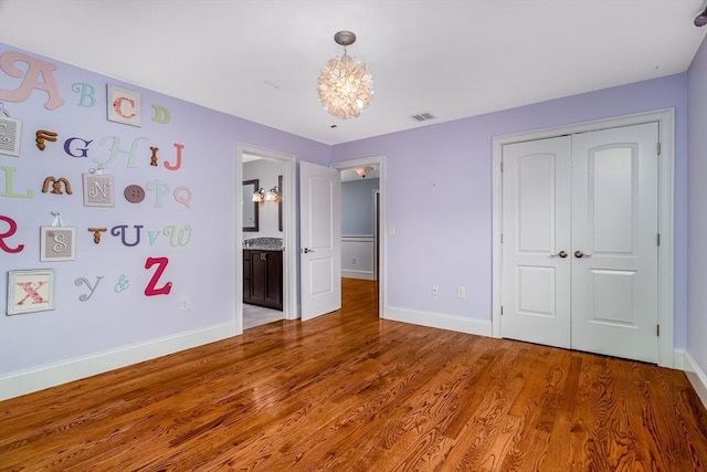 84 Bruce Rd, Concord, MA 01742 - unfurnished bedroom with a chandelier, baseboards, light wood-style flooring, and a closet