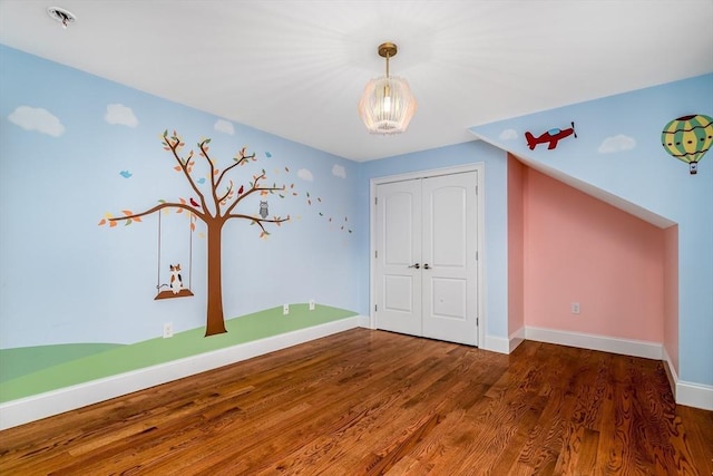 84 Bruce Rd, Concord, MA 01742 - unfurnished bedroom featuring wood finished floors, a closet, a chandelier, and baseboards