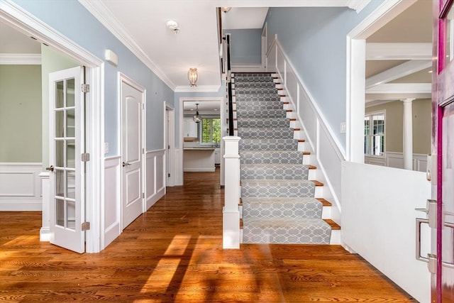 84 Bruce Rd, Concord, MA 01742 - entryway featuring a decorative wall, stairway, ornamental molding, wood finished floors, and a wainscoted wall