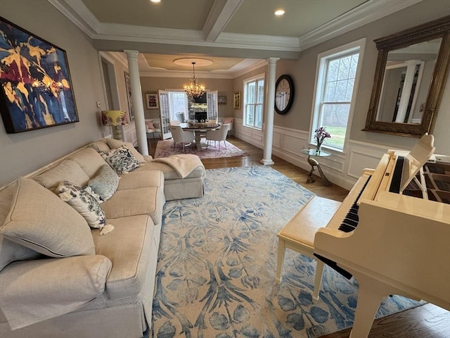 84 Bruce Rd, Concord, MA 01742 - living room featuring decorative columns, a chandelier, wood finished floors, crown molding, and wainscoting