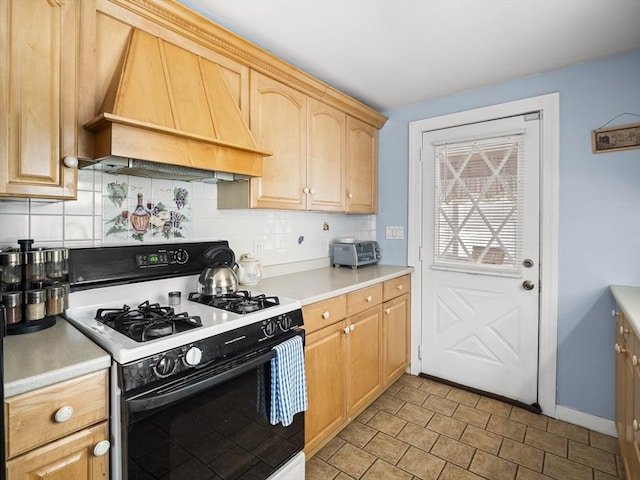 kitchen with tasteful backsplash, custom range hood, light countertops, light brown cabinets, and gas stove