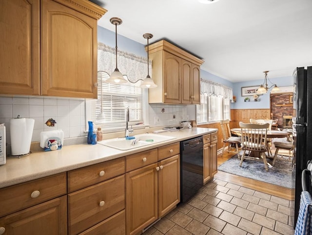 kitchen featuring black appliances, wainscoting, a sink, and light countertops