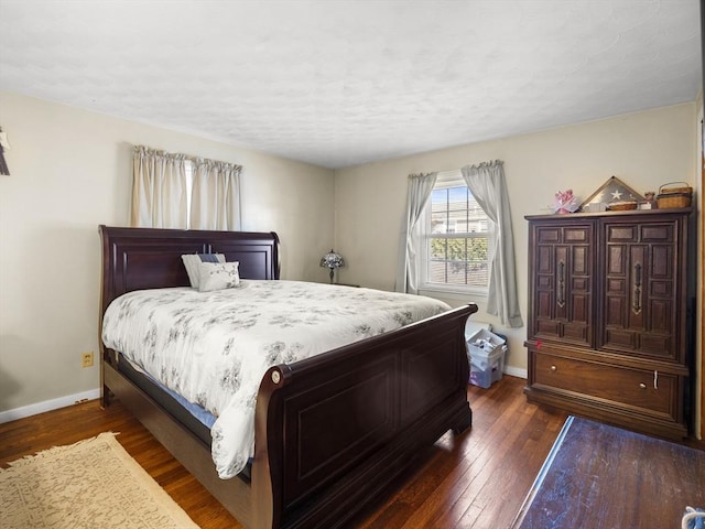 bedroom featuring dark wood-style floors and baseboards