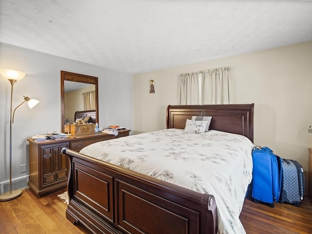 bedroom featuring visible vents, baseboards, and wood finished floors