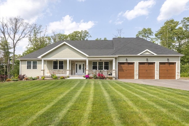 977 E St, Wrentham, MA 02093 - view of front of house featuring a porch, an attached garage, driveway, a front yard, and stone siding