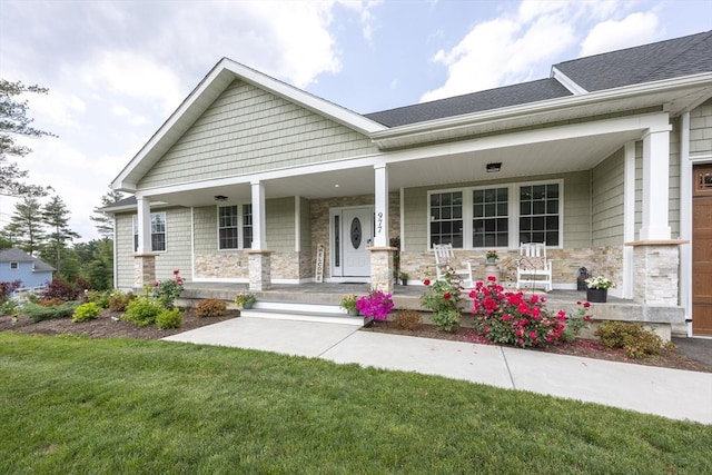 977 E St, Wrentham, MA 02093 - view of front of home featuring covered porch, stone siding, a front lawn, and roof with shingles