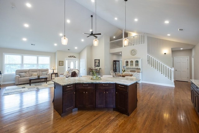 977 E St, Wrentham, MA 02093 - kitchen featuring dark wood-style floors, dark brown cabinets, open floor plan, ceiling fan, and high vaulted ceiling