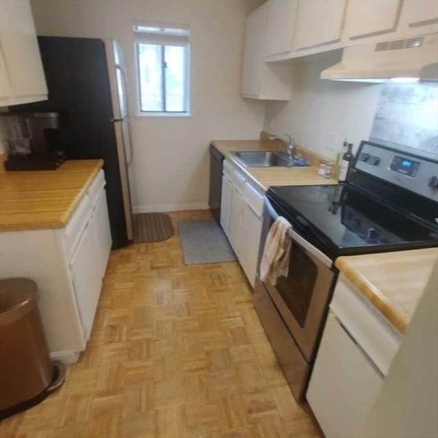 kitchen with electric stove, a sink, range hood, white cabinetry, and light countertops