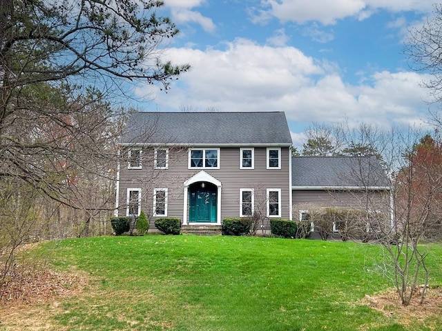 colonial house with a shingled roof and a front lawn