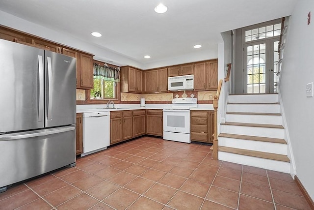 kitchen featuring backsplash, a sink, light tile patterned flooring, recessed lighting, and white appliances