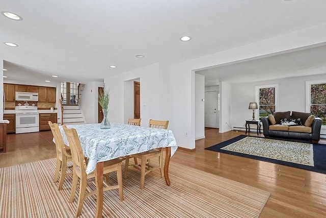 dining space featuring baseboard heating, recessed lighting, light wood-style flooring, and stairway