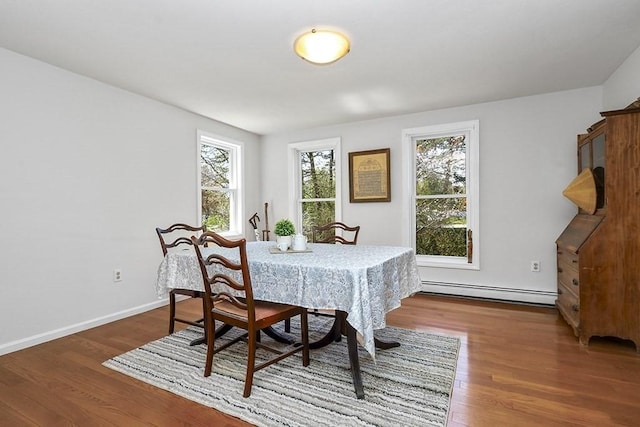 dining room with baseboards, baseboard heating, and wood finished floors