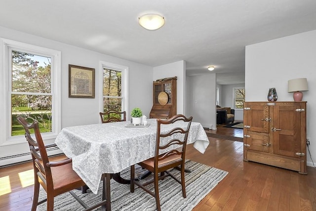 dining space with dark wood-style flooring and baseboard heating