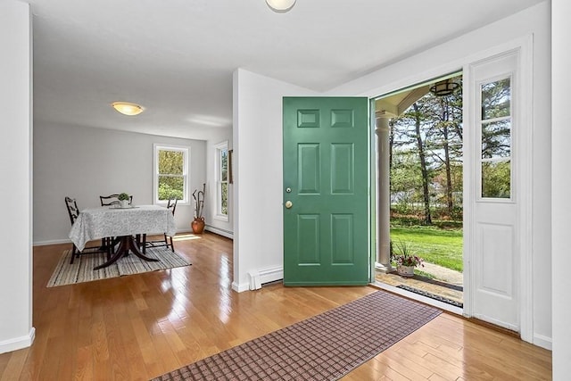 entryway with baseboards, a baseboard heating unit, and hardwood / wood-style flooring