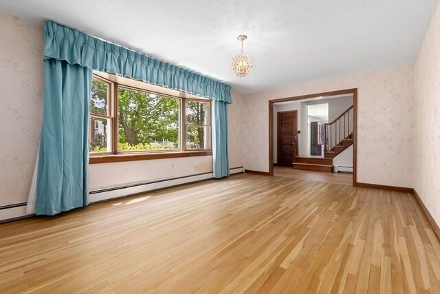 24 Flume Rd, Gloucester, MA 01930 - spare room featuring a baseboard heating unit, light wood-style floors, wallpapered walls, stairs, and a chandelier