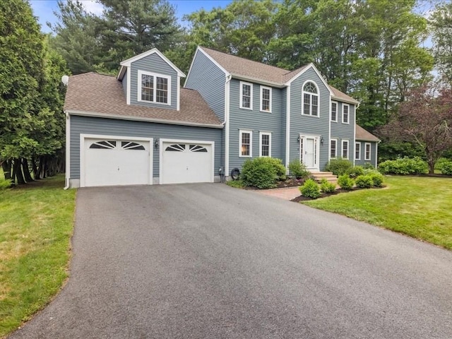 41 Nancy Dr, Ashland, MA 01721 - colonial-style house featuring asphalt driveway, an attached garage, a front yard, and roof with shingles