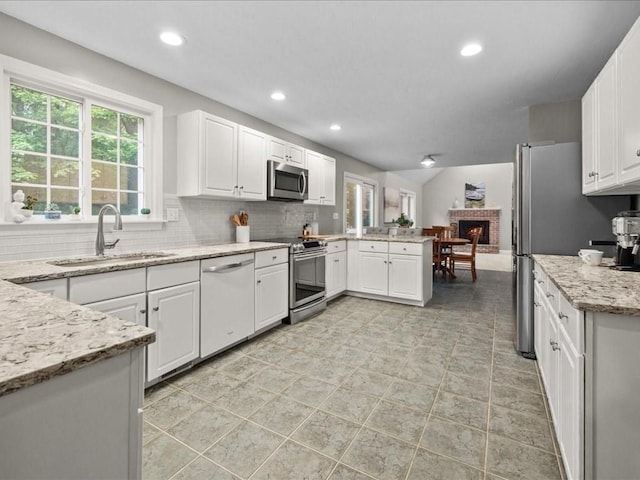 41 Nancy Dr, Ashland, MA 01721 - kitchen with stainless steel appliances, a peninsula, white cabinets, tasteful backsplash, and recessed lighting