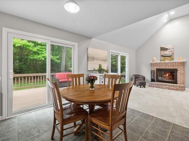 41 Nancy Dr, Ashland, MA 01721 - dining room with a brick fireplace, lofted ceiling, dark colored carpet, and dark tile patterned floors