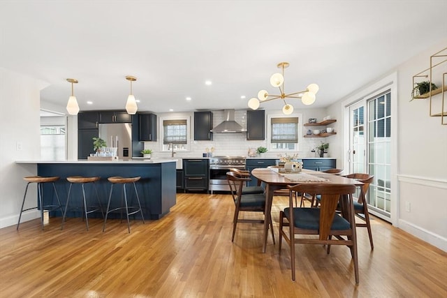 dining area featuring recessed lighting, light wood-type flooring, baseboards, and a notable chandelier