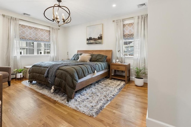 bedroom with visible vents, multiple windows, and wood finished floors