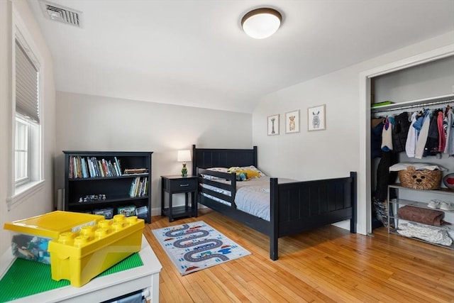 bedroom with a closet, visible vents, and wood-type flooring