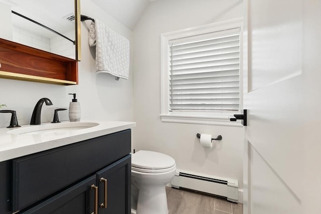 bathroom featuring vanity, wood finished floors, a baseboard radiator, lofted ceiling, and toilet