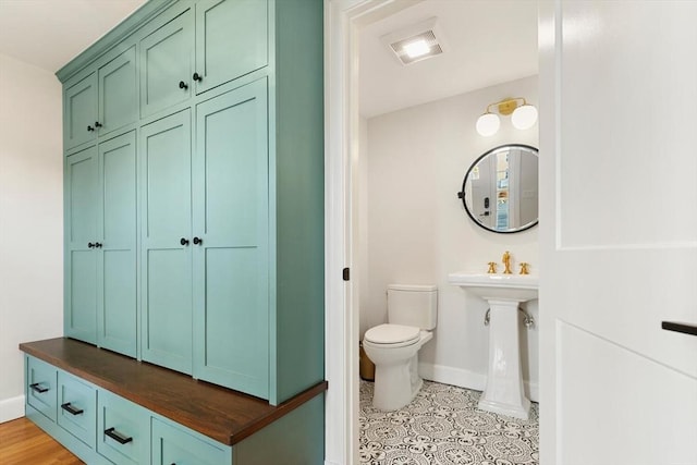 bathroom featuring visible vents, toilet, and baseboards