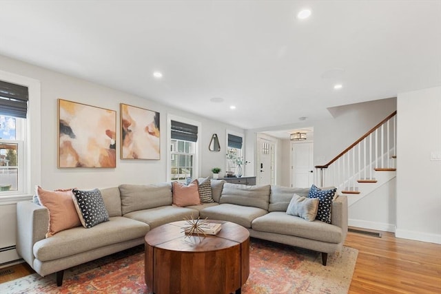 living area with recessed lighting, stairs, baseboards, and wood finished floors