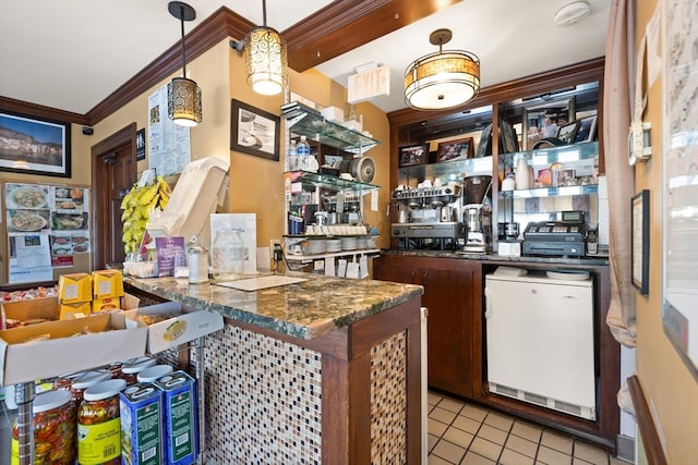 bar with pendant lighting, fridge, light tile flooring, crown molding, and dark stone countertops