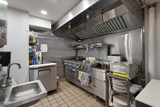 kitchen featuring fridge, double oven range, custom range hood, sink, and light tile floors