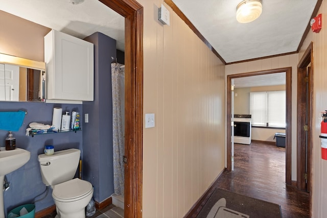 bathroom with hardwood / wood-style floors, toilet, and ornamental molding