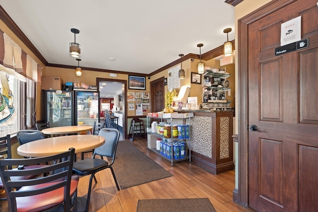 dining area featuring wood-type flooring and ornamental molding