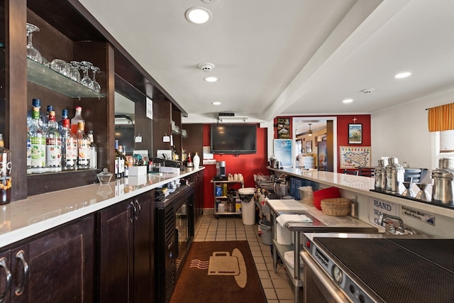 bar featuring dark brown cabinets and light tile floors