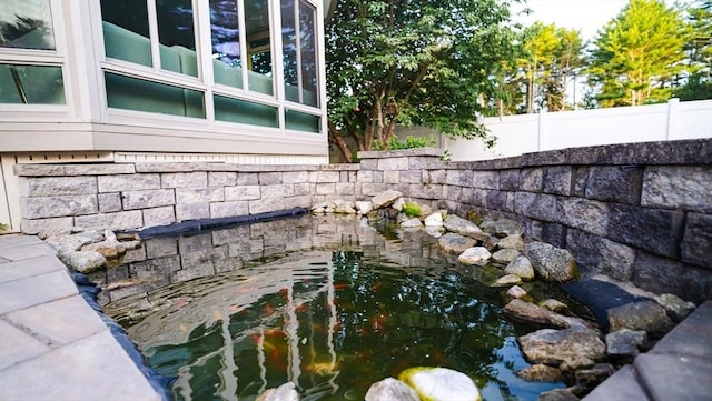 90 Braley Rd, Freetown, MA 02717 - exterior view of stone siding and a garden pond