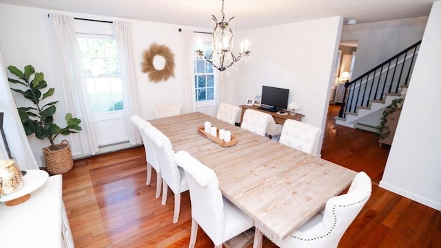 90 Braley Rd, Freetown, MA 02717 - dining area featuring a chandelier, stairway, wood finished floors, and a baseboard heating unit