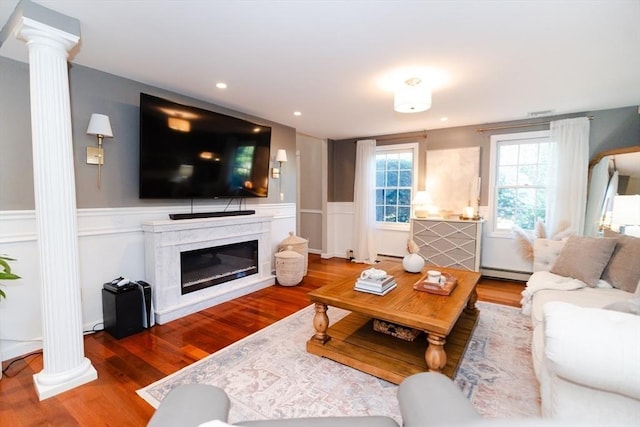 90 Braley Rd, Freetown, MA 02717 - living room featuring decorative columns, a baseboard heating unit, wood finished floors, wainscoting, and a fireplace
